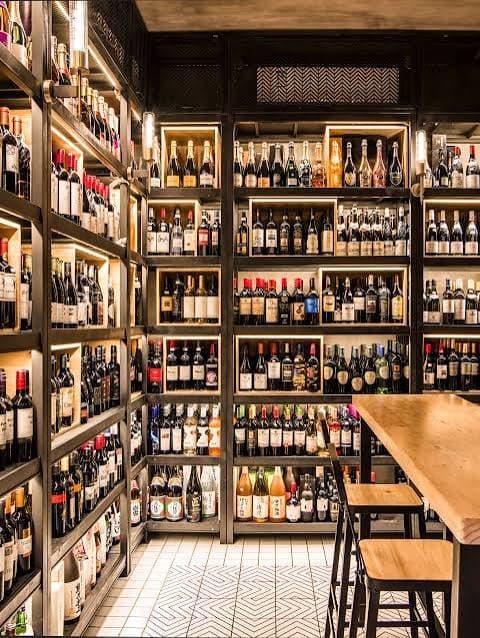 Inside a Zaks Premium store: floor-to-ceiling shelves of wine with a tasting counter